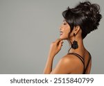 Fashion Asian Woman Face Side view with Wedding Hairstyle. Elegant Lady with Evening Hair Updo over Gray Background. Beautiful Woman with Black Earrings and Red Lips Side View