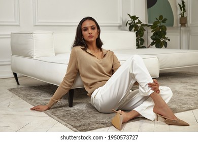 Fashion Beautiful Model Sexy Pretty Lady Dark Tanned Skin Woman Brunette Hair Wear White Pants Clothes Casual Office Style Or Romantic Date Or Party In Decoration Designer Room Home Or Hotel.