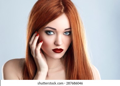Fashion Beauty Model Woman Long Red Hair. Red Matte Lips and Nails. Blue Eyes.
