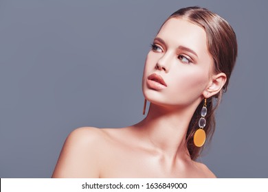 Fashion Beauty Portrait.  Attractive Fashion Model Posing In Earrings In The Avant-garde Style. Copy Space. 