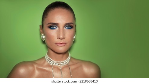 Fashion Beauty Portrait Of A Beautiful Woman In Pearl Jewerly With Smokey Eyes Make Up Against Green Background