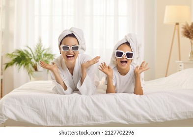 Fashion Beauty Portrait Of Happy Mother And Little Daughter Wearing Towels On Her Head And Fashionable Glasses. Family Cheerfully Exclaims Looking At Camera Having Fun At Home Or In Bright Hotel Room.