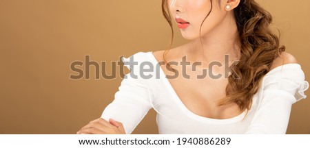 Fashion Beauty Woman has long black blonde hair and express feeling happy. Portrait of Asian girl wear white dress over yellow tone background, copy space