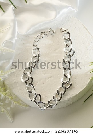 Fashion bijouterie - large silver chain bracelet on a white stand close-up