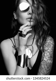 fashion black and white portrait of Beautiful sexy woman with tattoo. beauty tattooed girl in sunglasses and jewelry