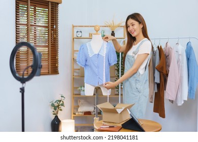 Fashion blogger concept, Asian women measure length of shirt to present and sell in streaming video. - Shutterstock ID 2198041181