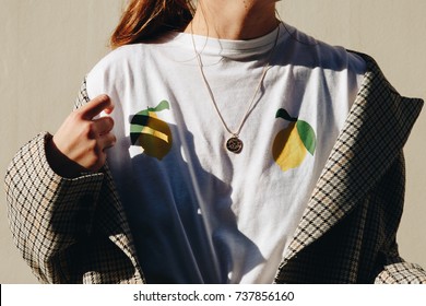 fashion blogger outfit details. fashionable woman wearing a checked oversized coat, white t shirt, denim skirt and a black trendy handbag. detail of a perfect fall fashion outfit.