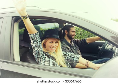 fashion blond girl in car with boyfriend ready to go in vacation with a car trip. Vintage