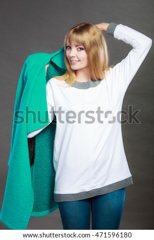 Fashion. Blonde girl fashionable woman trying blue coat dark background
