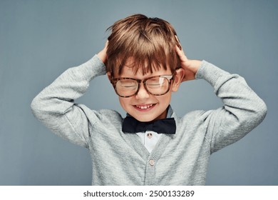 Fashion, bow tie and child in studio with headache for thinking, problem solving and stress. Intelligent nerd, genius and isolated young boy with head pain, frustrated and upset on gray background - Powered by Shutterstock