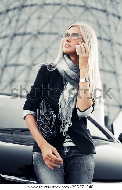 Fashion\
business woman calling on the phone at the car\
