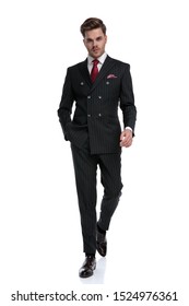 fashion businessman wearing double breasted suit and elegant brogue shoes, walking isolated on white background in studio