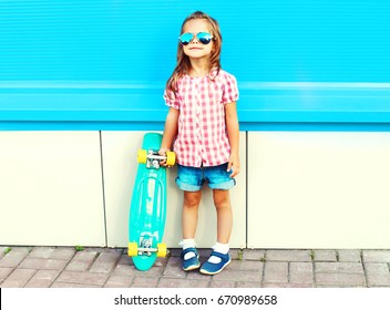 Fashion Child With Skateboard In The City On A Colorful Blue Background