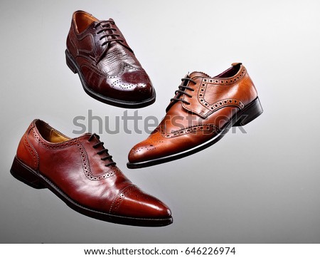 Fashion classical polished men's brown oxford brogues shades of brown oxford brogues.Conept flying shoes.Gray background.Copy space