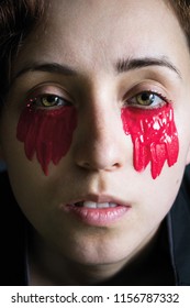 Fashion Close-up Portrait Of A Girl In Black Clothes With Red Paint Under The Eyes