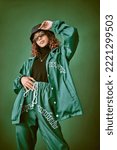 Fashion clothes, style and black woman with green rap, gen z or hip hop aesthetic outfit for cool, edgy or fashionable look. Designer brand apparel, attitude or teen fashion model on green background