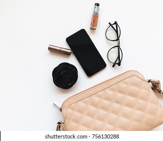 Fashion Concept : Flat Lay Of Brown Leather Woman Bag Open Out With Sunglasses And Smartphone On Wooden Background.