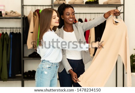 Fashion Consultant. Personal Stylist Choosing Fashionable Designer Clothing For Her Client In Showroom.