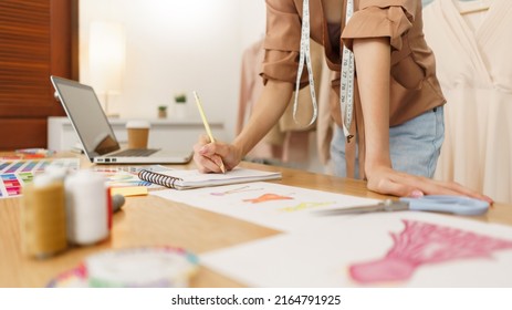 Fashion design concept, Asian female fashion designer sketching new clothes collection in atelier. - Shutterstock ID 2164791925