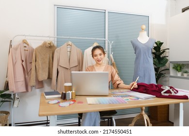 Fashion Design Concept, Asian Female Designer Look Data On Laptop And Choose Color On Color Sample.