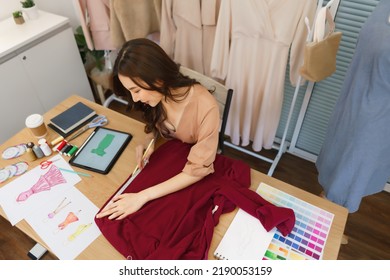 Fashion Design Concept, Asian Female Fashion Designer Measuring Fabric To Make Sewing New Dress.