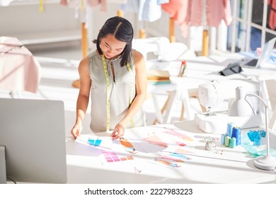 Fashion, designer and business woman working, thinking and planning creative collection in design studio. Asian, business owner and clothing expert choosing color, style and fabric alone in Tokyo - Powered by Shutterstock