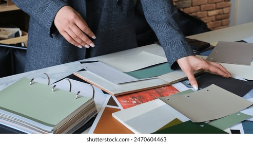 Fashion designer in collaborative meeting choosing fabric swatches. Creative discussion textile options and color palettes. Design professionals plan and innovate with various materials and patterns. - Powered by Shutterstock