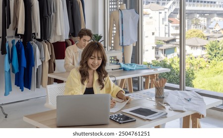 Fashion designer is focused on selecting colors for new clothing collection in studio. The workspace is filled with creative tools, fabric samples, sewing machine, vibrant process of fashion design - Powered by Shutterstock