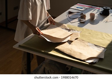 Fashion designer hold new sewing patterns on craft paper, unrecognizable closeup. Female tailor work with clothes models drafting in studio. Seamstress in atelier workshop. Tailoring business concept - Powered by Shutterstock