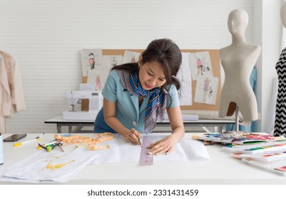 Fashion designer hovers over a design table in a well-lit studio, her workspace strewn with sketches, fabric samples, and tailoring tools; embodying fashion creativity at work. - Powered by Shutterstock