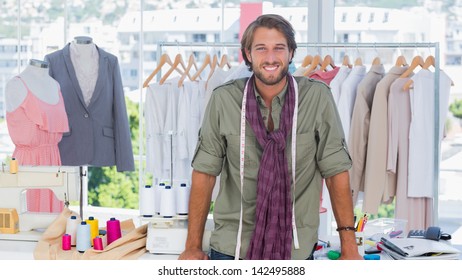 Fashion Designer Leaning On His Desk And Smiling To The Camera