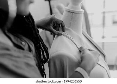 Fashion designer measuring a blazer on a pinnable mannequin