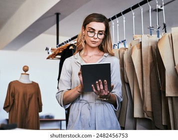 Fashion designer, small business and woman on tablet with clothes, material and fabric in creative studio. Retail boutique, tailor and person on digital tech for online order, research and planning - Powered by Shutterstock