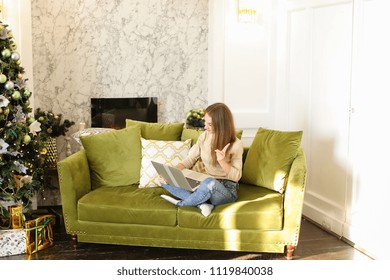 fashion designer speaking with parents using videocall on laptop, young woman go to business trip abroad. Fair-haired lady wearing beige T-shirt jeans smiling sitting on comfortable sofa. Concept of - Shutterstock ID 1119840038