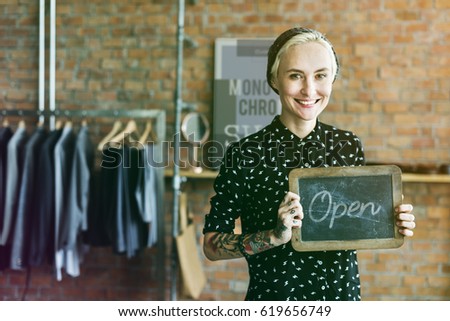 Fashion designer tattooed girl holding open shop banner
