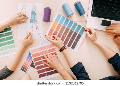 fashion designers developing new collection. creative team meeting at design studio. male and female coworkers selecting colors and sewing strings for dresses.  - Powered by Shutterstock