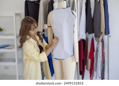 Fashion designers use pins and sewing thread to prepare patterns for cutting and sewing into simple garments. At a crafted design studio, the process of creating matching pieces for the collection. - Powered by Shutterstock