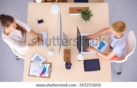 Foto Bild Junge Mitarbeiter im Startup diskutieren am Schreibtisch