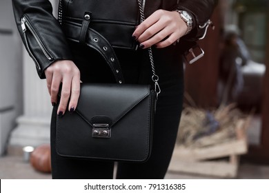 Fashion Details,stylish Outfit,accessories, Woman Holding Small Bag, Toned Colors, Street Style.detail Of A Fashionable Woman Wearing An Black Bomber Jacket, Silver Watch And A Black Trendy Handbag