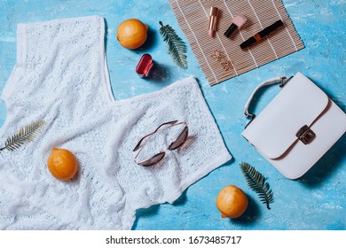 Fashion female clothes and accessories for beach destinations or summer vacation. Flat lay with woman white clothing, straw hat and purse, make up on sea blue background, woman travel fashion concept - Shutterstock ID 1673485717