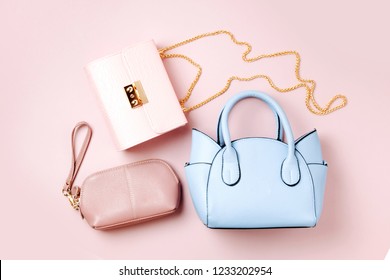 Fashion handbags on pale pink background. Flat lay, top view. Spring/summer fashion concept in pastel colored
