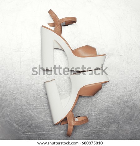 Fashion high heels shoes on a textured silver background
