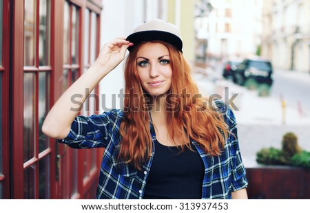 Fashion hipster cool girl wearing a shirt and cap in the city having fun outdoors. 