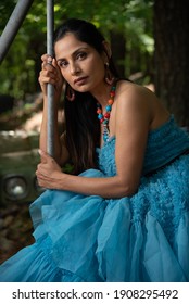 Fashion Image Of Beautiful Asian Indian Woman Wearing Blue Gown In A Junk Yard. 