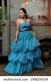 Fashion Image Of Beautiful Asian Indian Woman Wearing Blue Gown In A Junk Yard. 