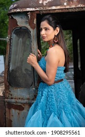 Fashion Image Of Beautiful Asian Indian Woman Wearing Blue Gown In A Junk Yard. 