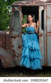 Fashion Image Of Beautiful Asian Indian Woman Wearing Blue Gown In A Junk Yard. 