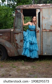 Fashion Image Of Beautiful Asian Indian Woman Wearing Blue Gown In A Junk Yard. 