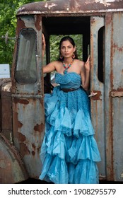 Fashion Image Of Beautiful Asian Indian Woman Wearing Blue Gown In A Junk Yard. 