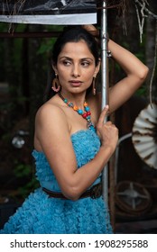 Fashion Image Of Beautiful Asian Indian Woman Wearing Blue Gown In A Junk Yard. 